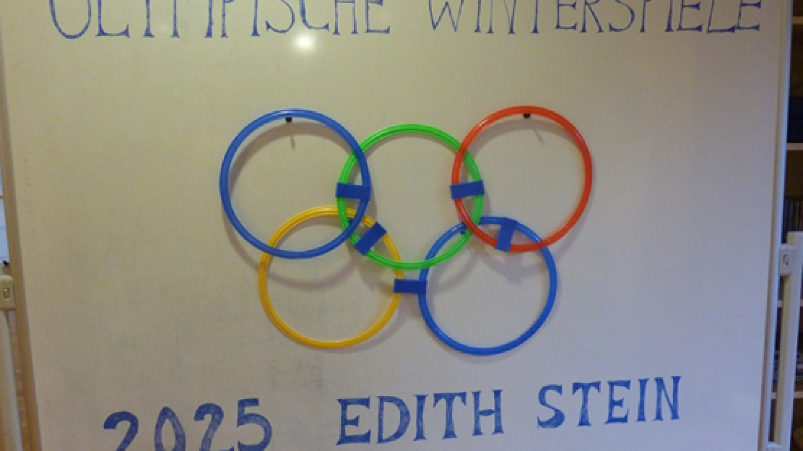 Schriftzug Olympische Winterspiele mit fünf bunten Ringen